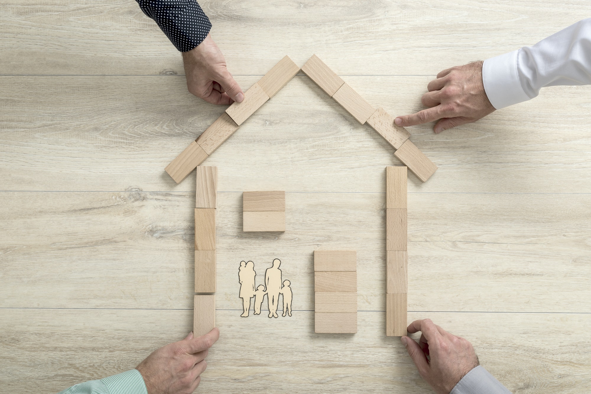 People making the shape of a residential house for a family